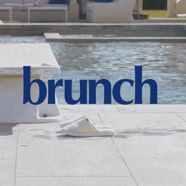 White poolside slippers beside a diving board with large overlaid text reading brunch