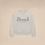 Light heather grey crewneck sweatshirt with 'Brunch' script and small text 'enjoy your stay' on the chest.