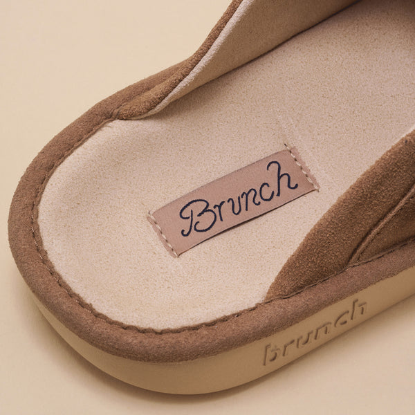 Sandstone suede slide with fabric insole tag reading Brunch and embossed brunch on the sole