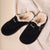 Black suede slip-on clogs with cream shearling lining and visible "Brunch" embroidery on top
