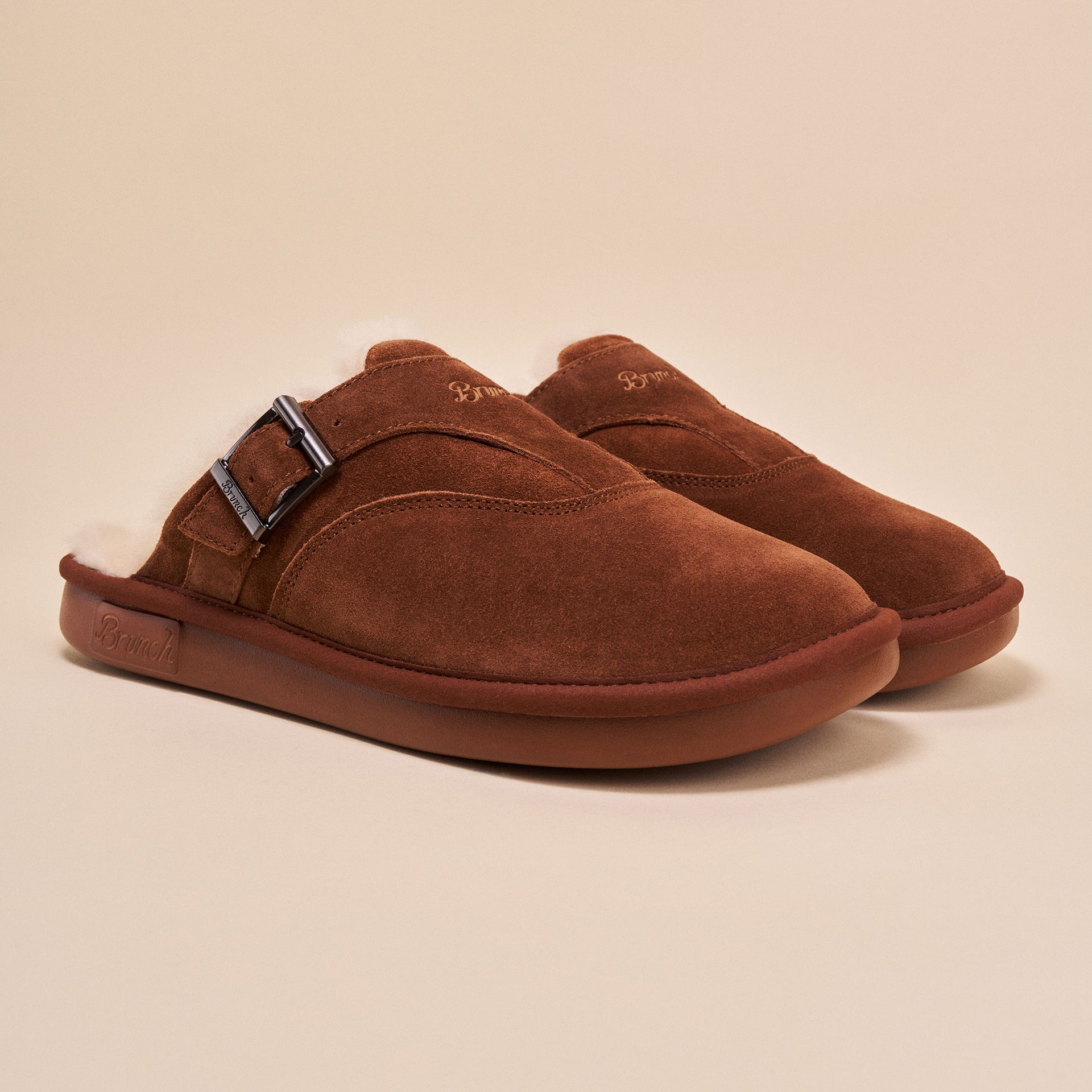 Brown suede slip-on slippers with buckle, shearling lining and Brunch logo on sole and upper