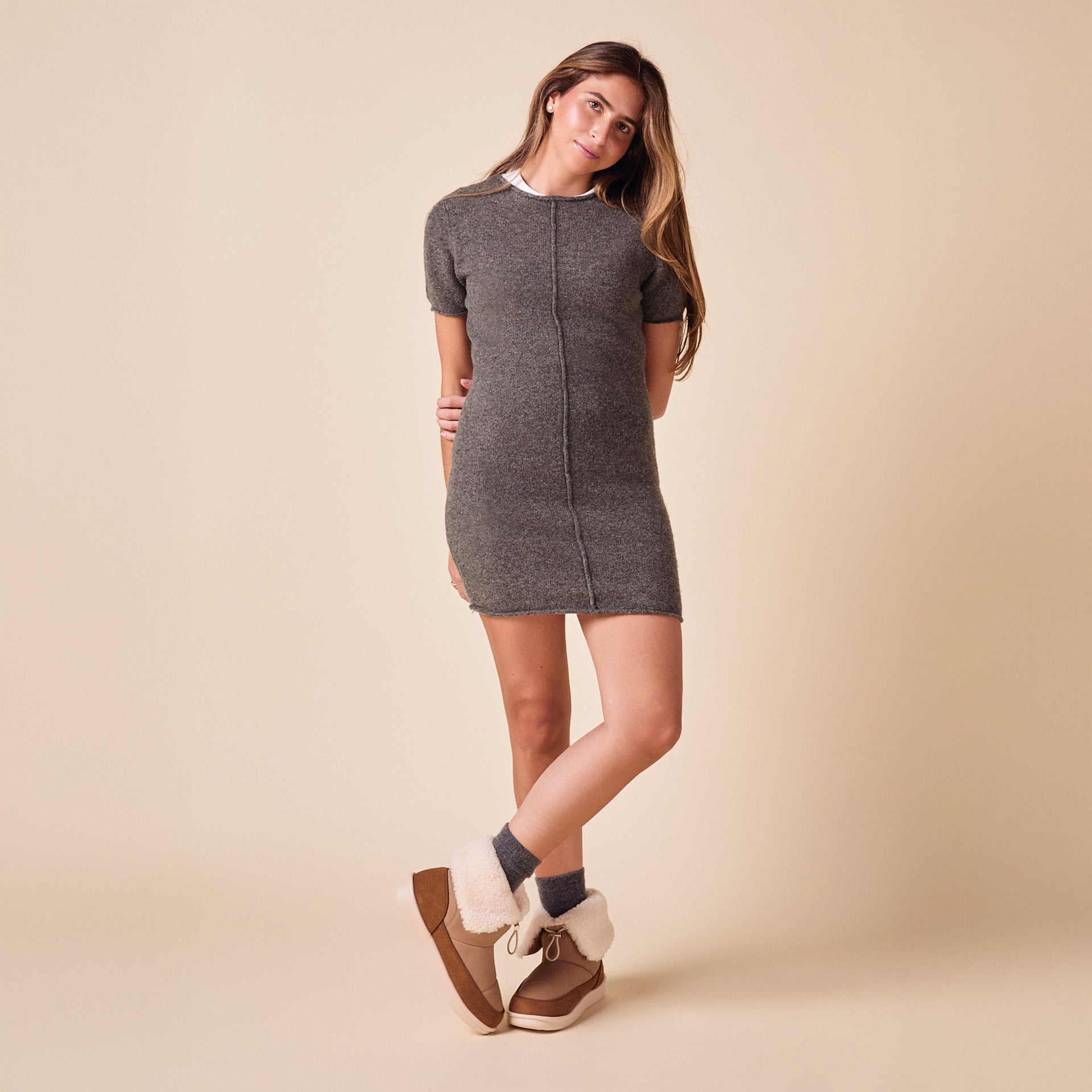 Gray short-sleeve knit mini dress with center seam, paired with camel shearling-lined ankle boots