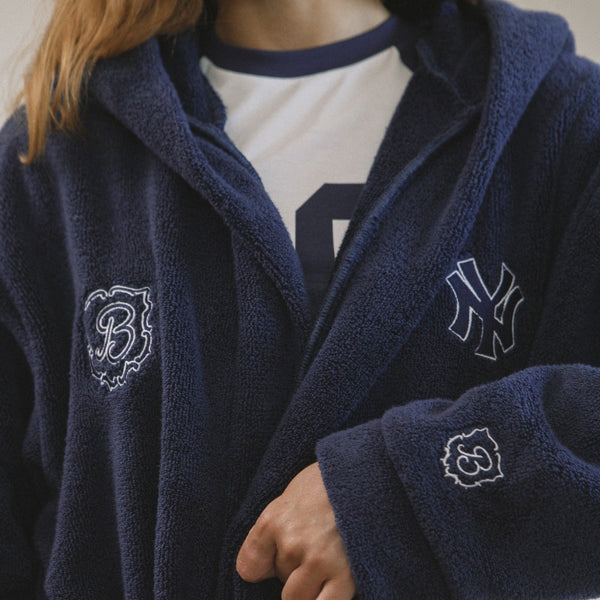 Navy blue robe with embroidered logos worn by a person