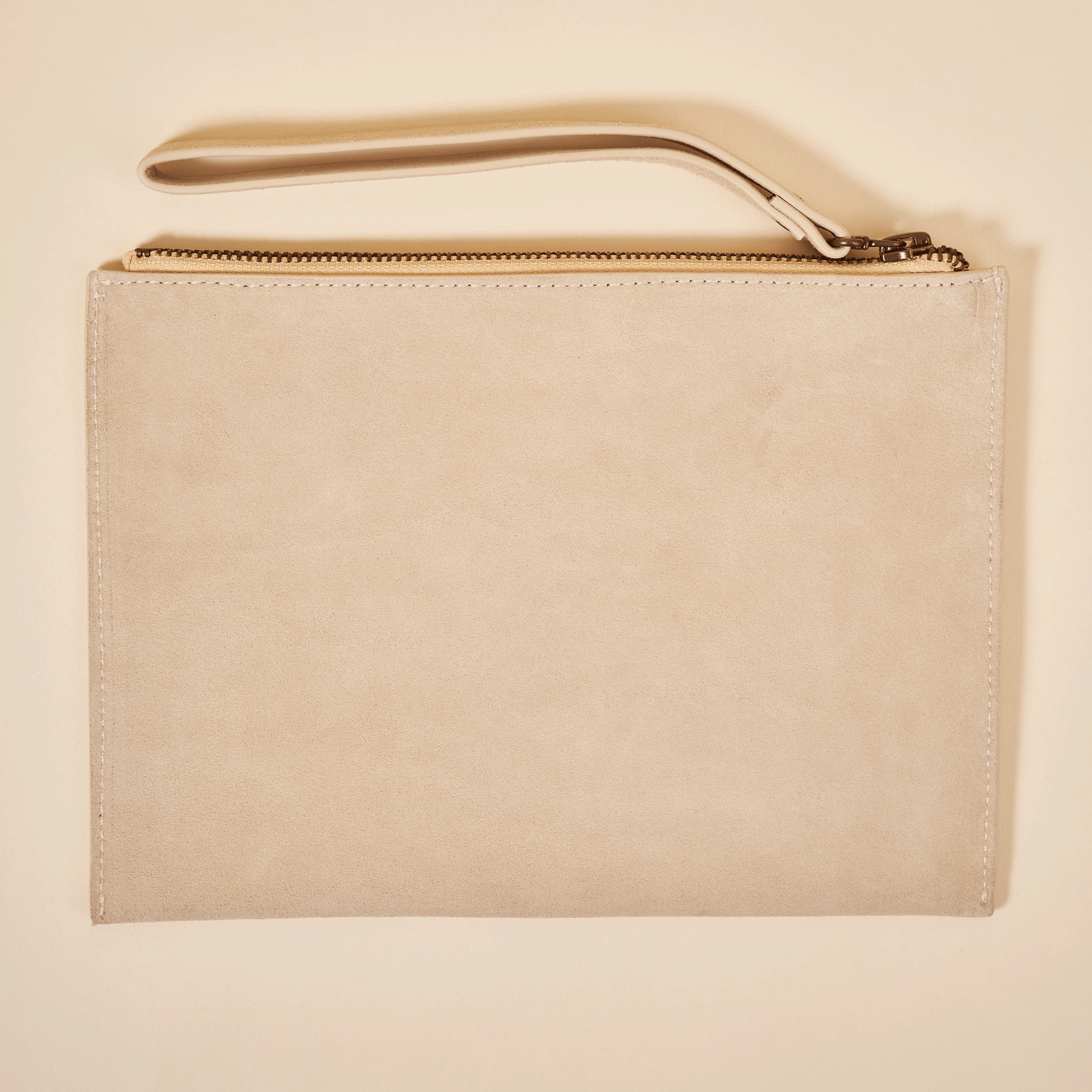 Beige suede wristlet pouch with top zipper and short wrist strap