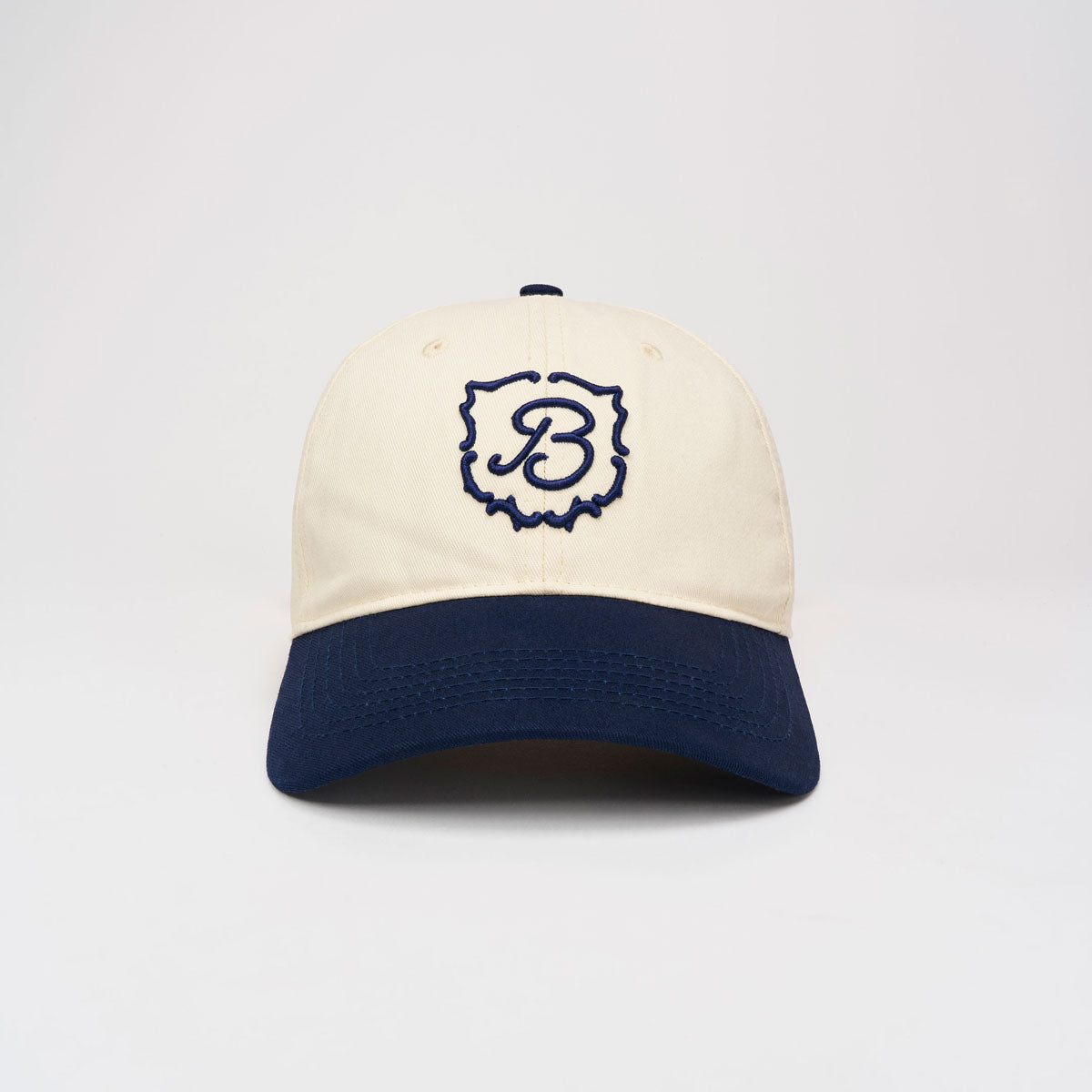 Front view of Retro Crest Cap in cream with navy brim showcasing embroidered navy B crest against a plain light gray background