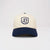 Front view of Retro Crest Cap in cream with navy brim showcasing embroidered navy B crest against a plain light gray background