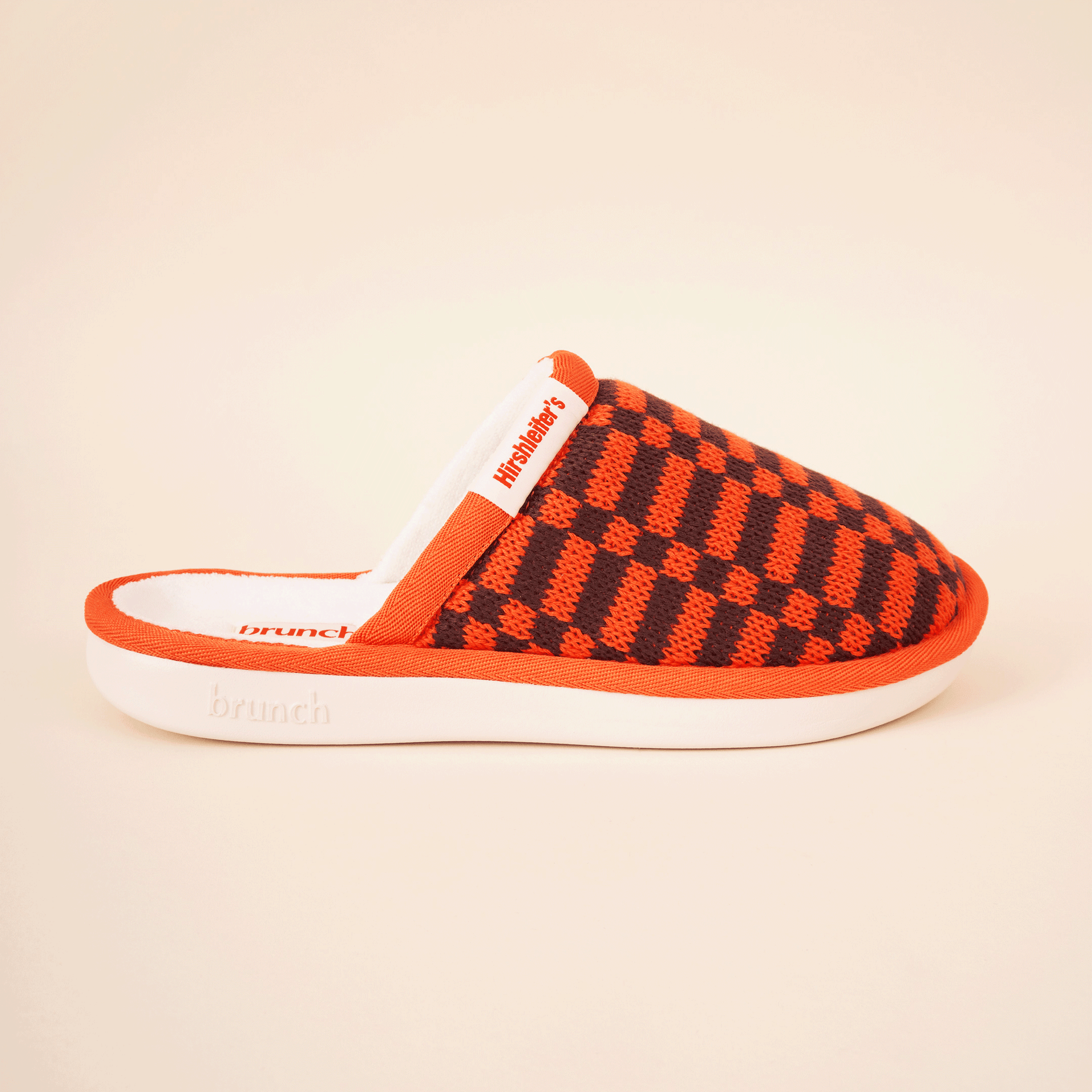 Orange-and-brown checkered slip-on slipper with white sole; label 'Hirshleiter's' and 'brunch' visible.