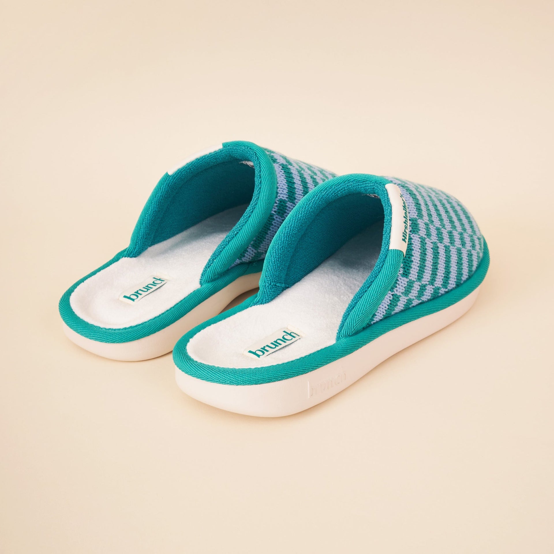 Teal slip-on house slippers with checkered knit upper and white cushioned insoles labeled brunch