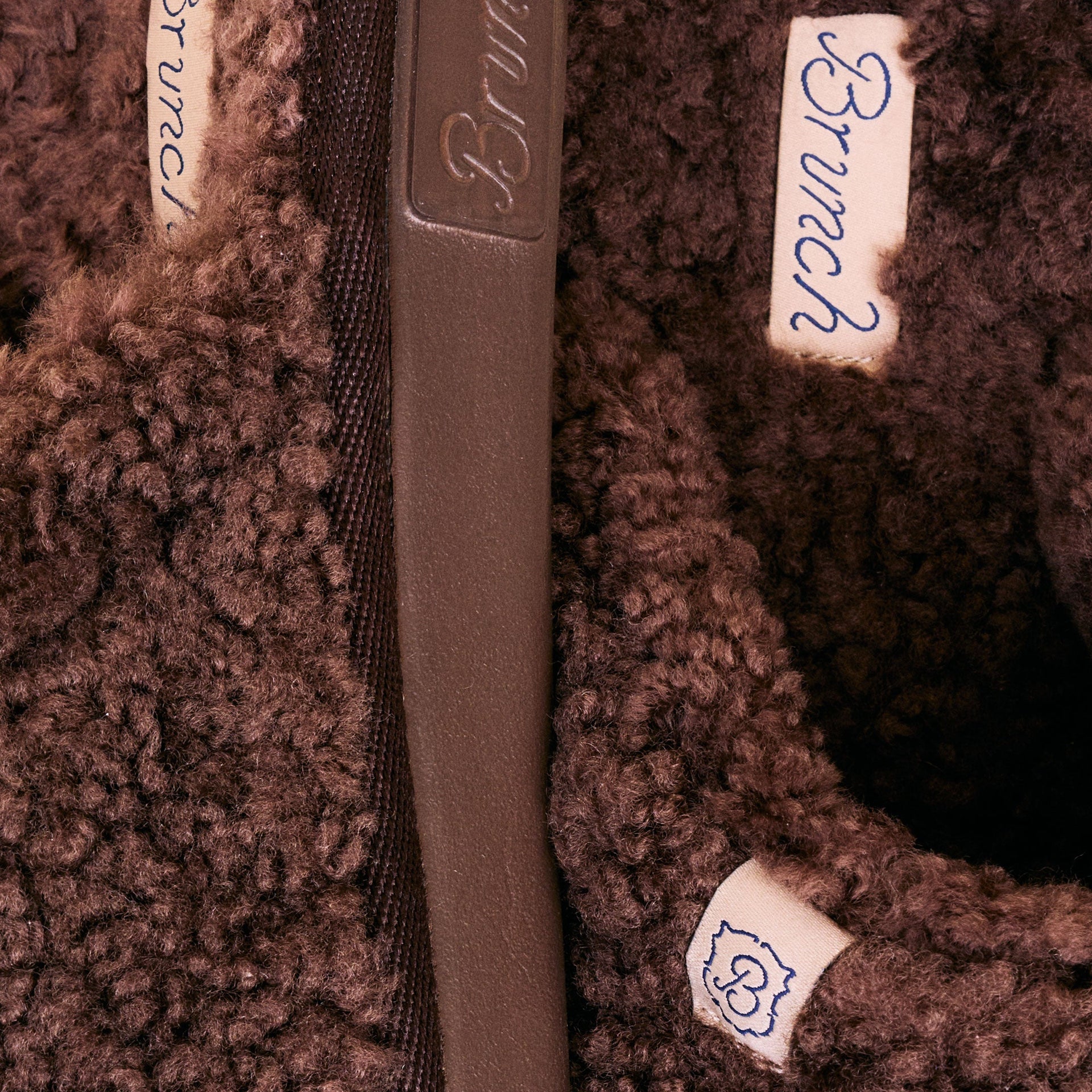 Close-up of brown shearling lining with sewn tags reading Brunch and a small B logo.