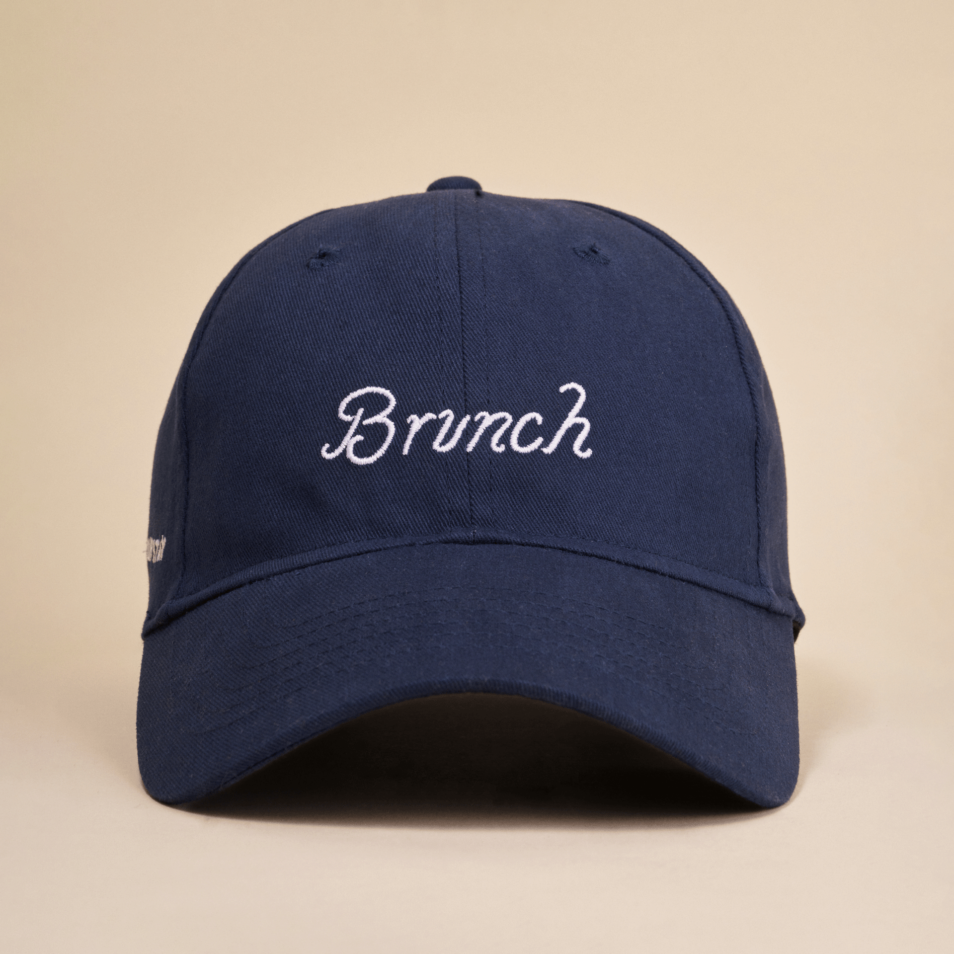 Navy baseball cap with white embroidered script 'Brunch' on the front