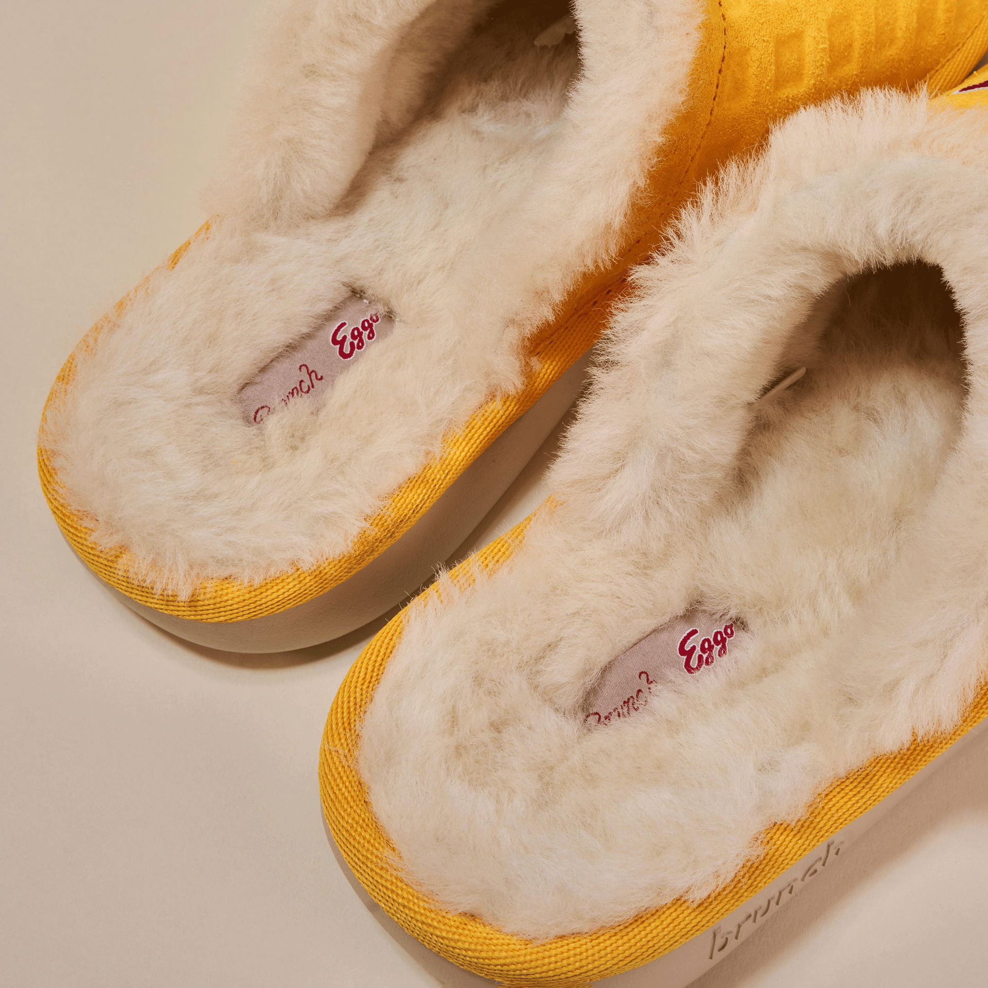 Yellow slip-on clogs with cream shearling lining and insole tag reading 'Brunch? Eggo'.