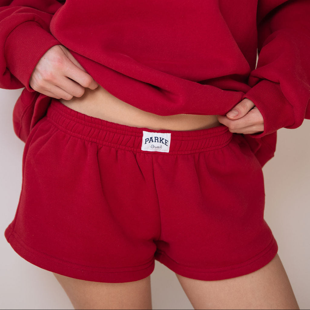 Red sweatshirt and shorts set with 'Packe' branding on a plain background