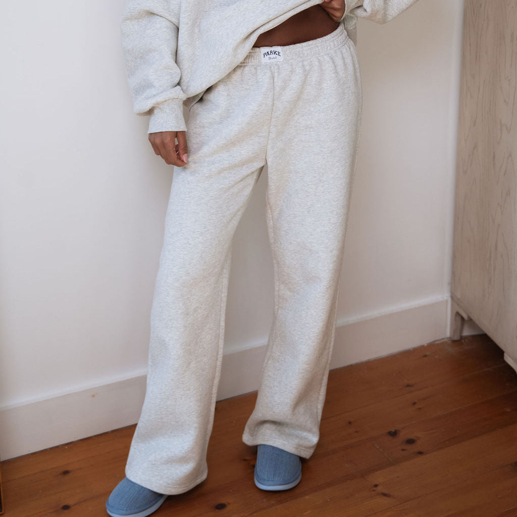 Person wearing a 'Parker' branded sweatshirt and pants in a room with wooden flooring.