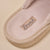 Beige slipper interior with fabric label reading Brunch stitched into the insole.