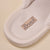 Cream fabric slipper insole close-up showing sewn label reading 'Brunch'