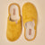 Mustard-yellow fuzzy slip-on slippers with 'Brunch' label on the insole