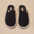 Black corduroy slip-on slippers with white trim, insole label 'Brunch' and small 'B' logo