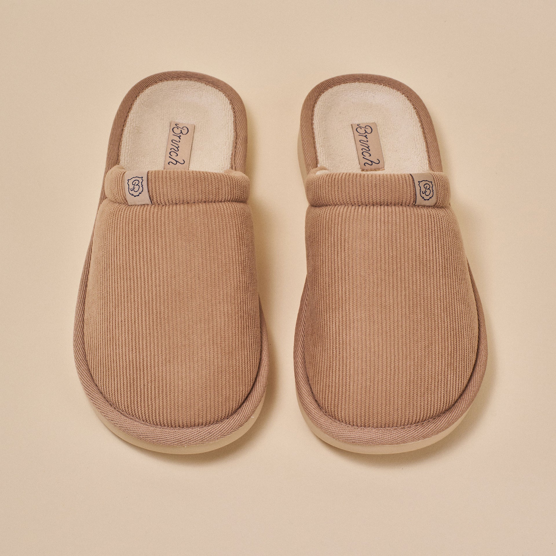 pair of caramel corduroy slip-on slippers, top view, insole label 'Brunch' and small 'B' emblem