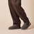 dark gray terry slip-on slippers worn with brown trousers, low-profile sole