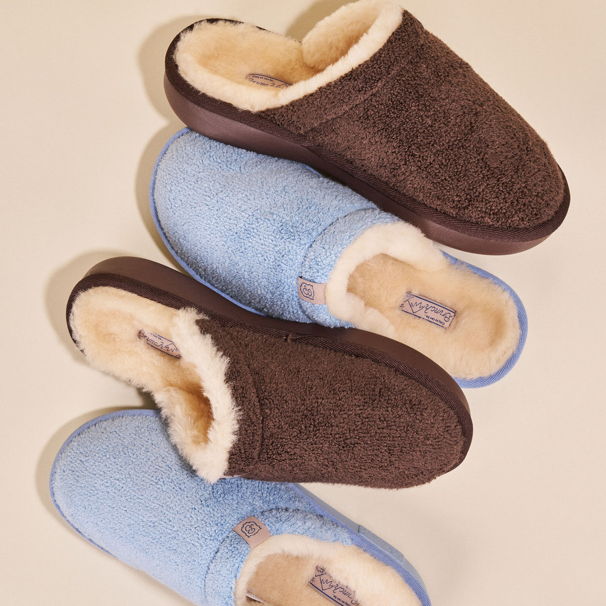 Pair of brown and blue slippers with fluffy interior on a beige background