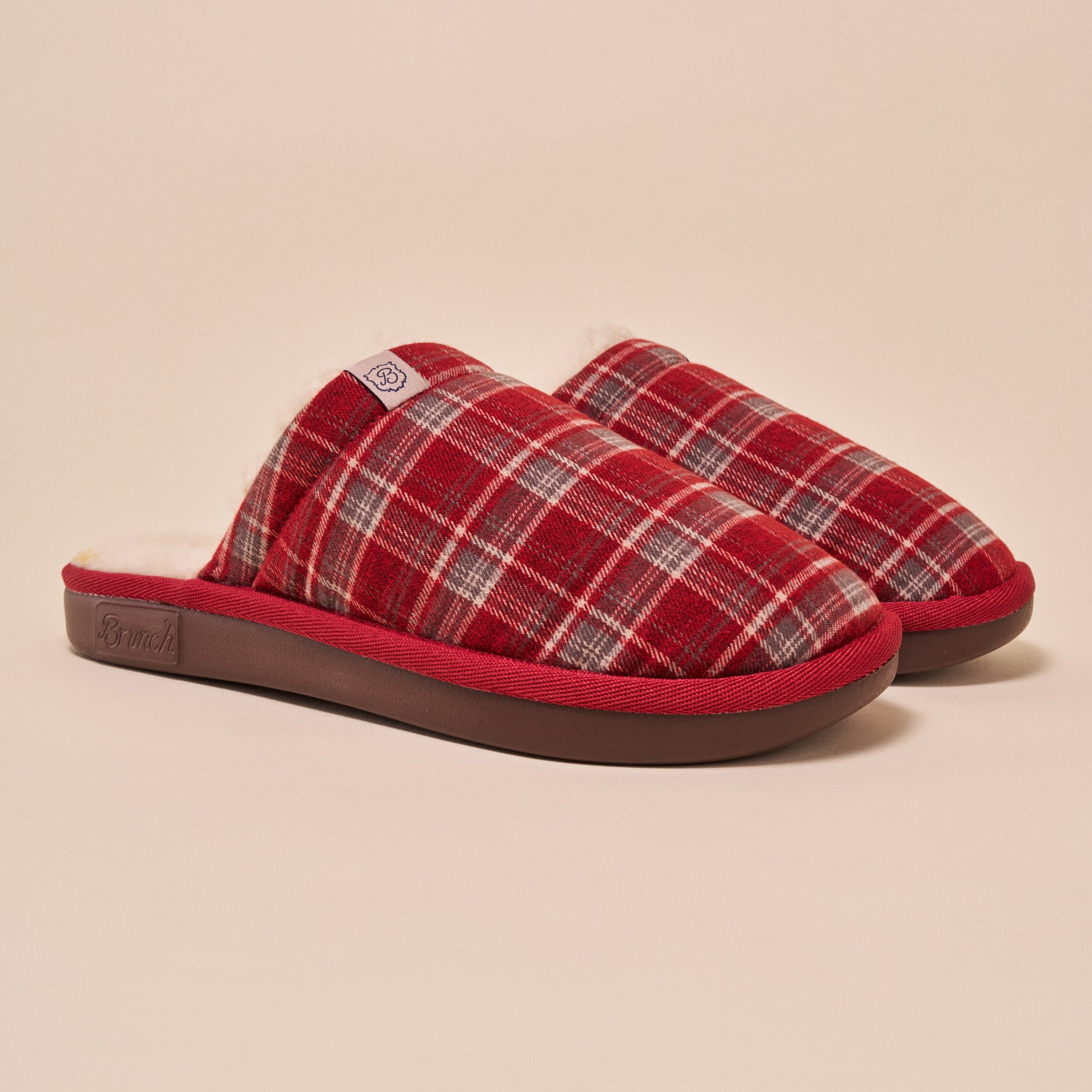 Red plaid slip-on house slippers with fleece lining and "Brunch" embossed on the sole