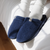 Angled top view of Essential navy terry slipper showcasing plush terry upper and molded sole on a white bed