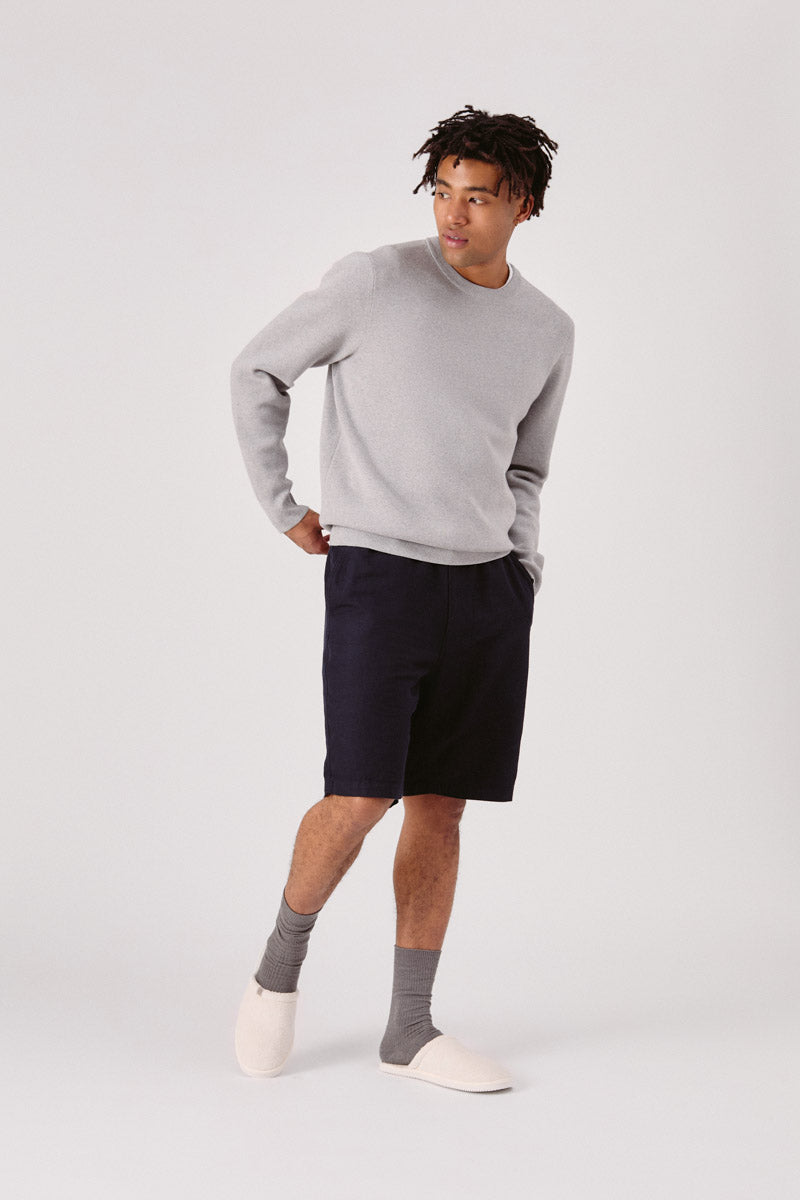 Three quarter view of The Classic slipper in cream on a model showing terry upper and Vibram sole on a plain light background