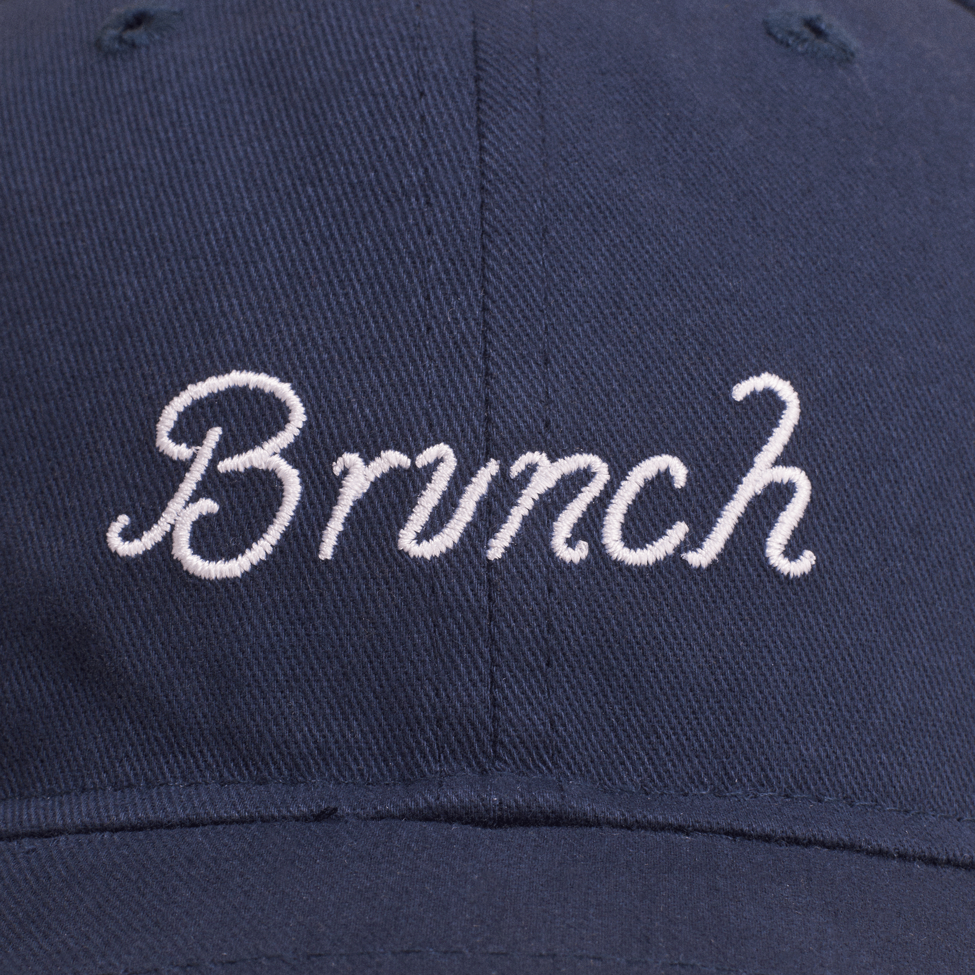 Navy baseball cap with white embroidered cursive 'Brunch' on front