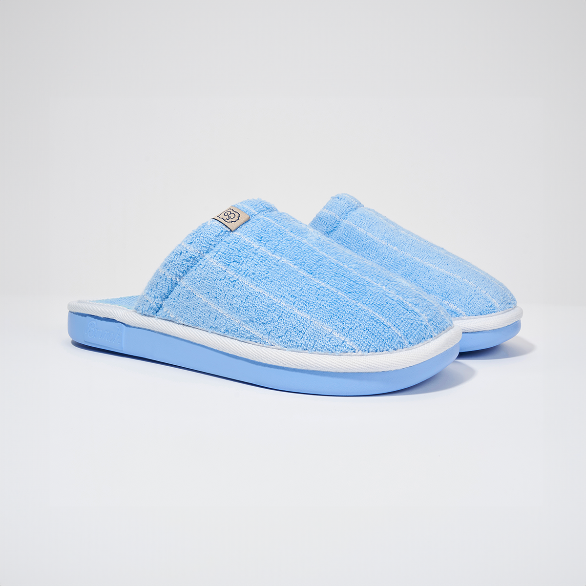 Angled view of Essential Cabana striped terry slipper showcasing blue and white cotton terry upper and blue EVA sole on white background
