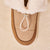 Top view of Apres Boot in camel nubuck showing folded shearling cuff, gold toggle, suede trim on cream sherpa background