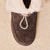 Top view of Apres Boot in dark brown suede showing folded shearling collar and front toggle loop on cream sherpa background
