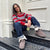 Woman sitting on outdoor steps wearing dark brown suede Apres boots with folded shearling cuff, holding an iced drink