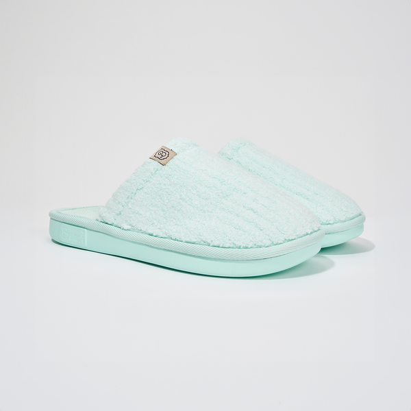 Angled view of Lido Essential slipper in aqua showcasing ribbed terry upper, low open-back silhouette, and cushioned foam sole on white background