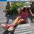 Angled view of Boat Mule Dusty Rose suede mule showcasing open-back silhouette and pink beaded laces on a wooden deck