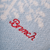 Close-up of Essential Cashmere slipper upper showing light blue knit cashmere texture and red embroidered Brunch logo