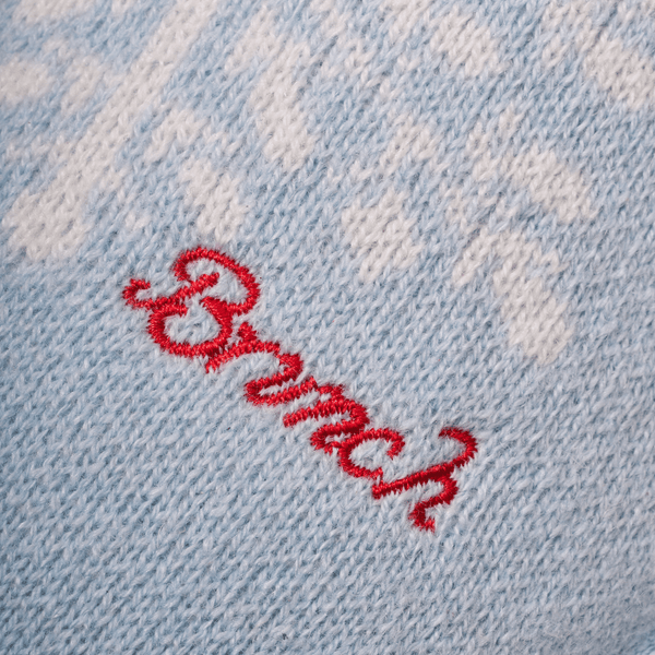 Close-up of Essential Cashmere slipper upper showing light blue knit cashmere texture and red embroidered Brunch logo