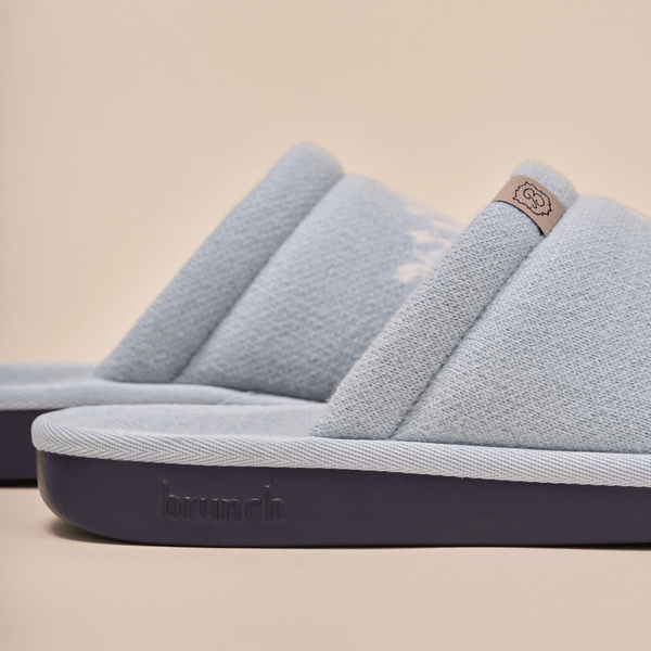 Side view of Essential Cashmere slipper in baby blue showing cashmere upper and navy embossed outsole