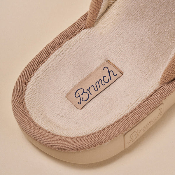 Close-up of Essential Corduroy slipper interior showing terry footbed and stitched Brunch label on caramel corduroy trim