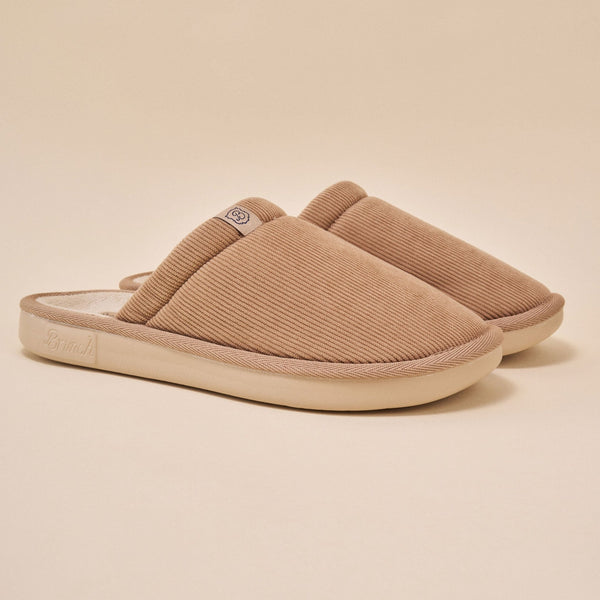 Side view of Essential Corduroy slipper in caramel showing ribbed corduroy upper and low profile outsole on beige background