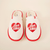 Top-down view of cream and red Diet Coke shearling slip-on slippers showcasing red heart "diet coke" embroidery and faux shearling lining on cream background