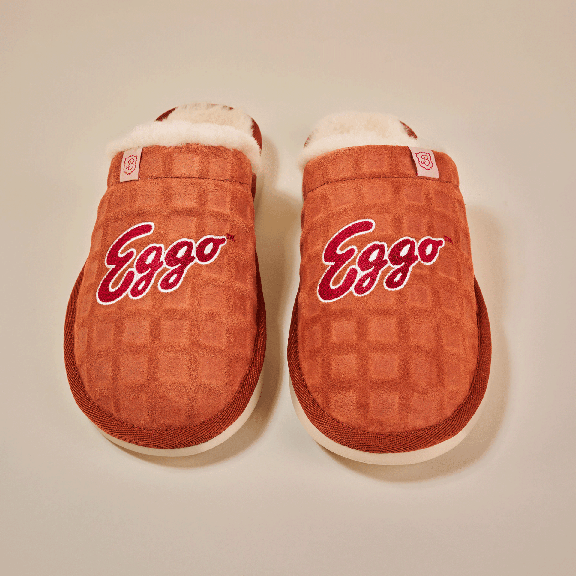 Top view of Essential Eggo slippers in syrup brown showing waffle-embossed suede upper, embroidered Eggo logo and cream shearling lining