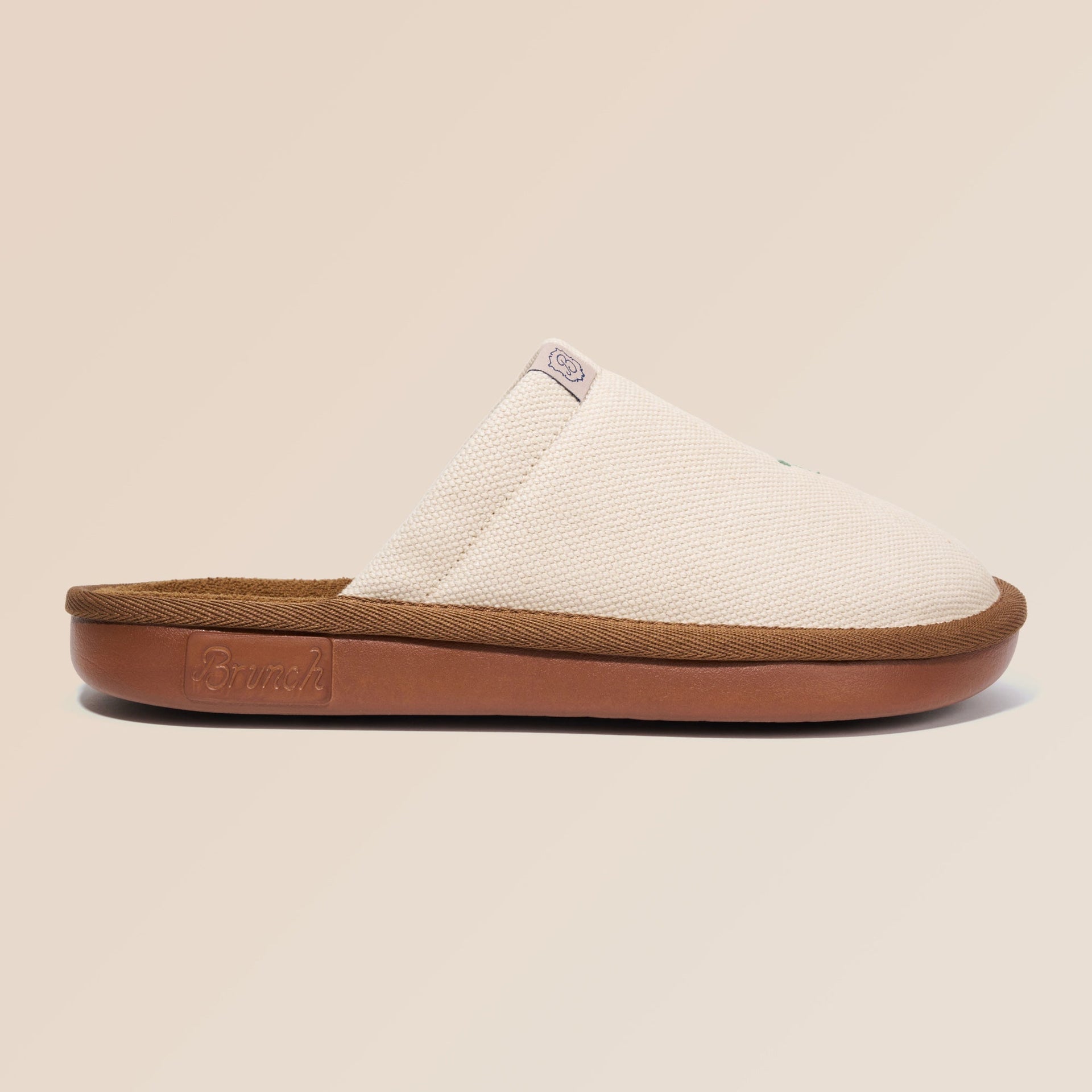 Side view of beige Essential Floral canvas slipper with sunflower embroidery and brown cushioned sole on neutral background