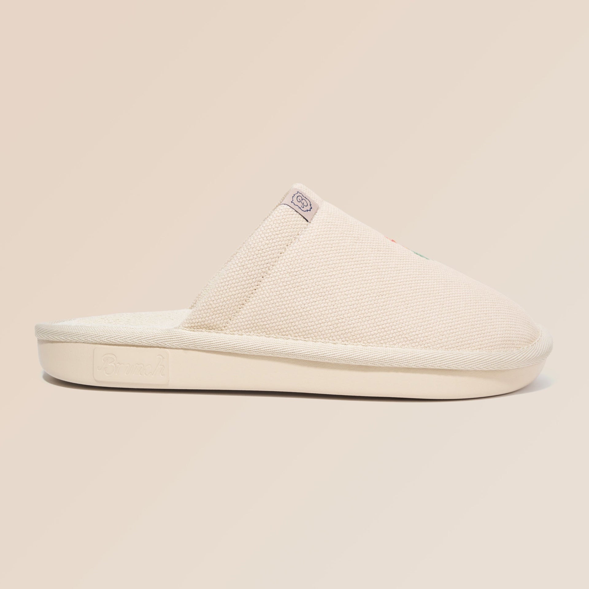 Side view of Essential Floral canvas slipper in beige Wildflower showcasing hand-stitched floral embroidery on a neutral beige background