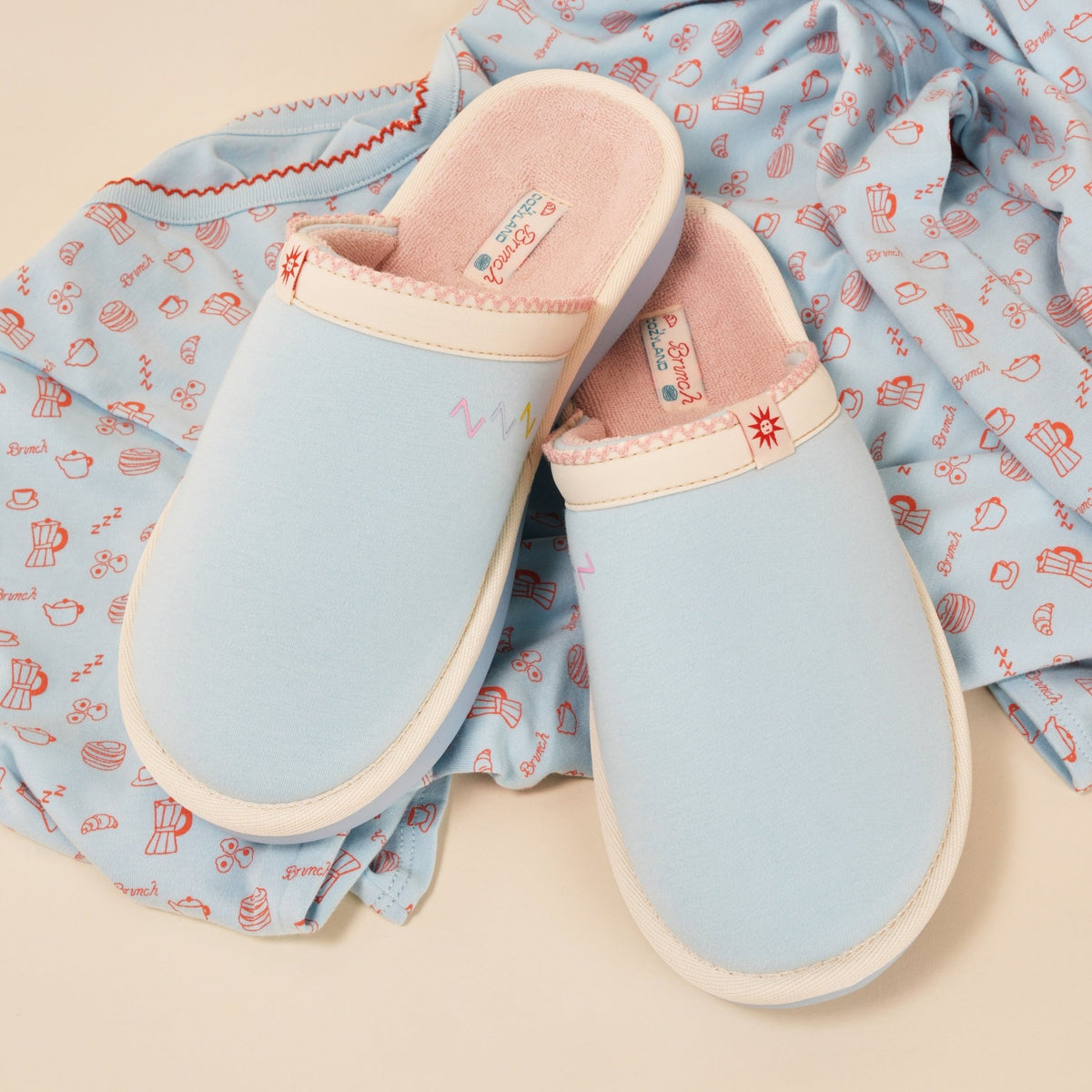 Top view of Essential Cozyland slippers, French Blue, showing pink terry lining and cushioned sole on printed pajama fabric