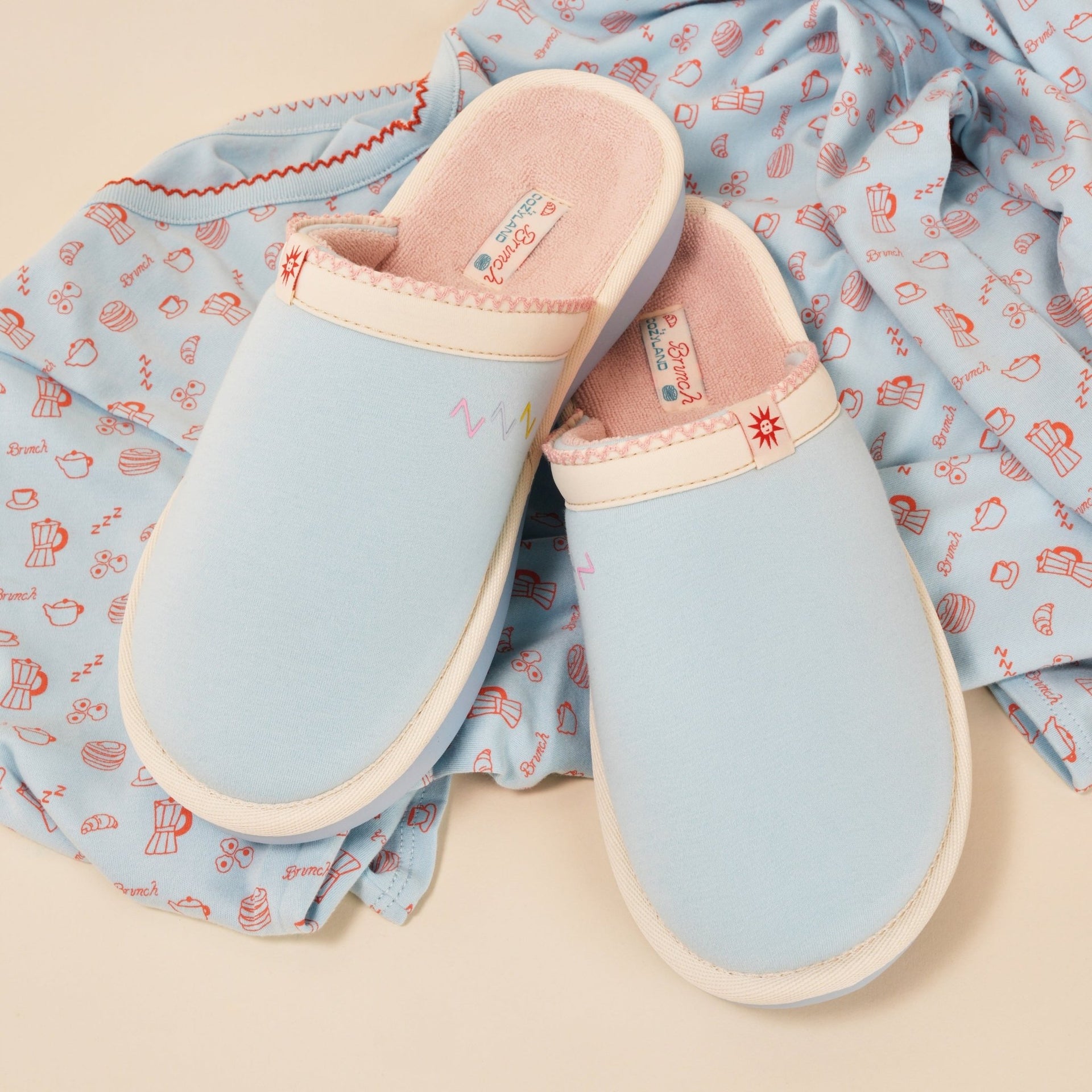 Top view of Essential Cozyland slippers, French Blue, showing pink terry lining and cushioned sole on printed pajama fabric