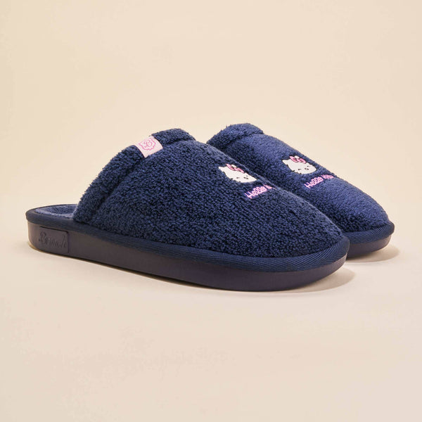 Three-quarter view of navy terry Hello Kitty slip-on slippers with embroidered Hello Kitty faces and pink accents