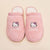 Top view of Essential Hello Kitty terry slippers showcasing embroidered Hello Kitty faces on pink terry fabric with cream background