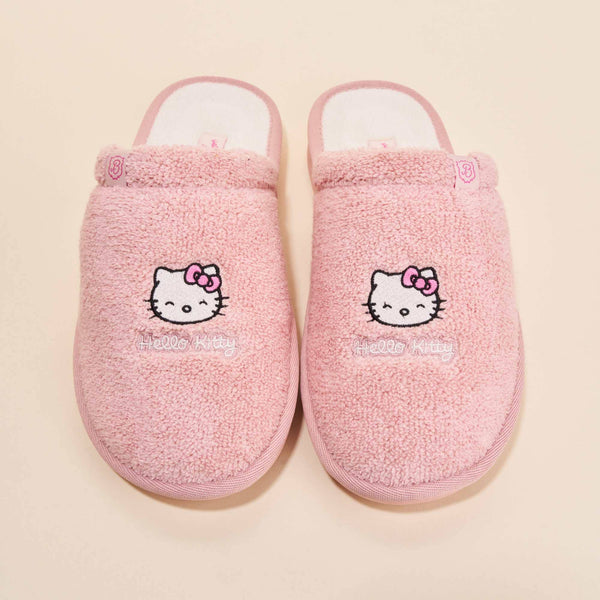 Top view of Essential Hello Kitty terry slippers showcasing embroidered Hello Kitty faces on pink terry fabric with cream background