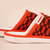 Side view of Amber knit slipper with orange and brown pattern, white terry lining, Hirshleifer's tag and embossed brunch sole