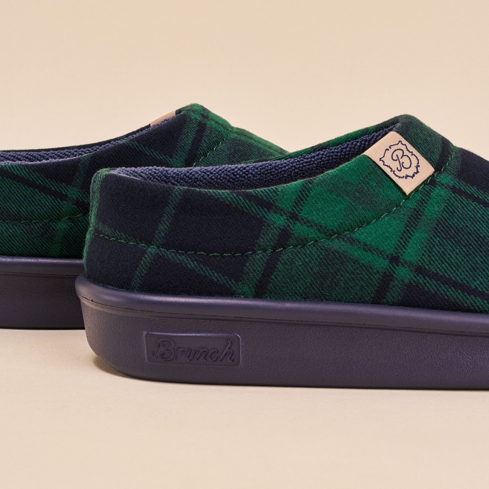 Side close up of Essential Kids slipper in navy and green plaid showing cushioned navy EVA sole and recycled polyester upper